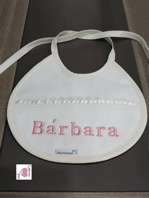 Primer plano de un babero de bebé con el nombre bordado.