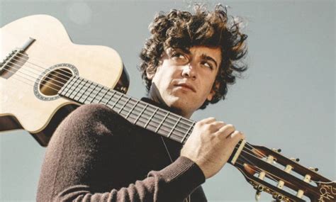 Retrato del artista Guitarricadelafuente sosteniendo su guitarra acústica con un estilo minimalista y evocador.