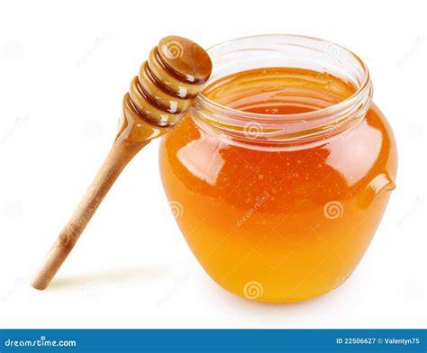 Miel en un tarro de cristal con panal de abejas al fondo