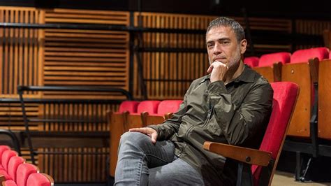 Retrato profesional de Julio Manrique en un entorno teatral, destacando su expresión como actor y director