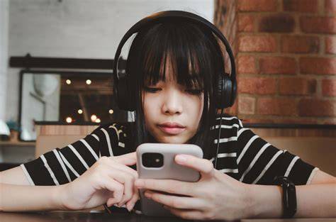 Foto de un adolescente usando un smartwatch o cascos inalámbricos