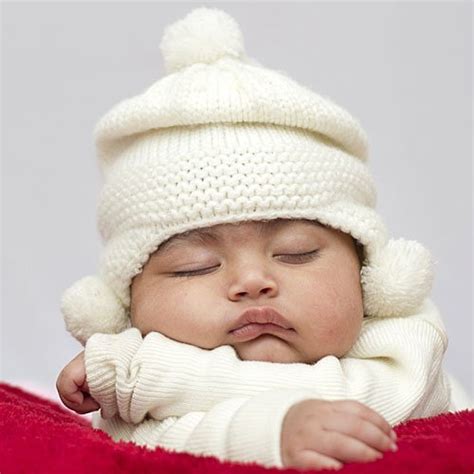 Bebé abrigado con varias capas de ropa y un gorro en un día frío.