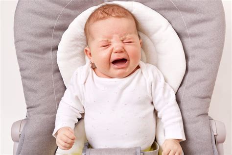 Bebé llorando con signos de cólico (piernas encogidas, espalda arqueada)