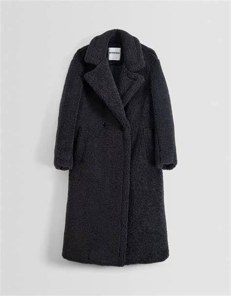 Imagen de atmósfera invernal mostrando una variedad de abrigos para bebé: una trenca clásica, un abrigo acolchado y una pequeña parka con capucha de pelo