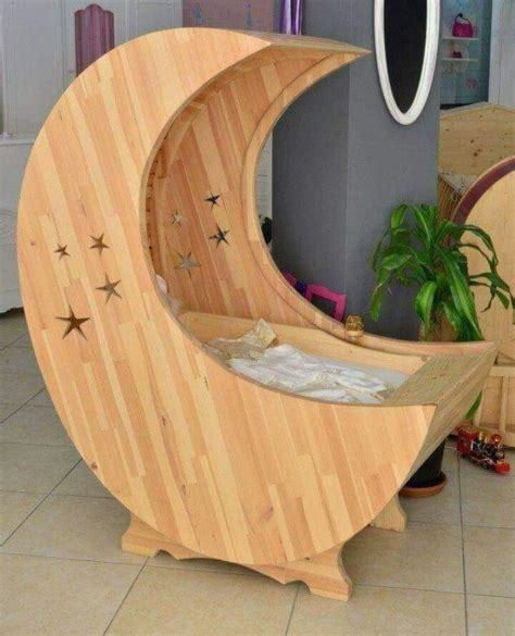 Diseño conceptual de una cuna en forma de media luna fabricada en madera natural con detalles de estrellas talladas