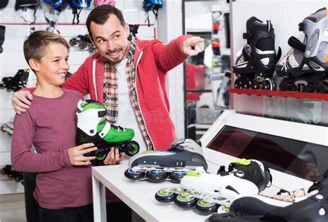 Padre ayudando a su hijo a probar una moto de juguete en una tienda, verificando la altura.