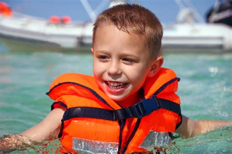 Niño usando un chaleco salvavidas en el mar