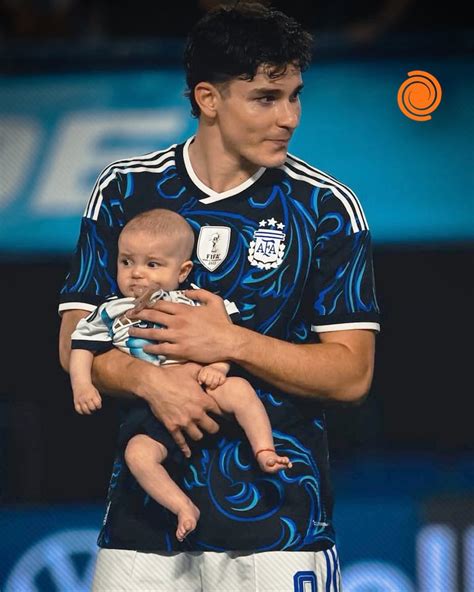 Julián Álvarez con su hijo Amadeo en brazos en el césped de La Bombonera