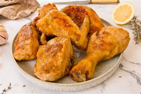 Foto de un pollo asado dorado y crujiente, recién salido del asador con guarnición