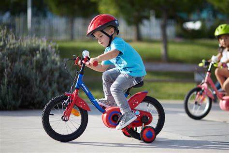 Niño de 4 años en bicicleta sin pedales o en una bicicleta de 14 pulgadas, feliz y sonriente.