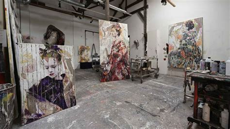 Fotografía de Lita Cabellut en su estudio, rodeada de lienzos y materiales de arte.