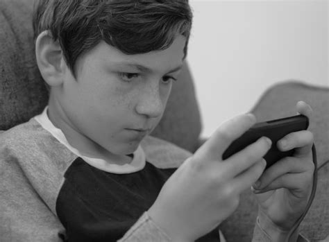 Foto de niños preadolescentes usando un teléfono móvil de forma supervisada