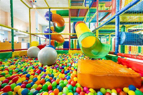 Interior de restaurante familiar con un pequeño parque de bolas y mesas cerca