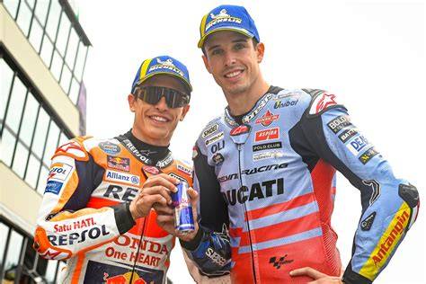 Fotografía de Marc Márquez junto a su hermano Álex Márquez compartiendo un momento en el paddock durante un Gran Premio.