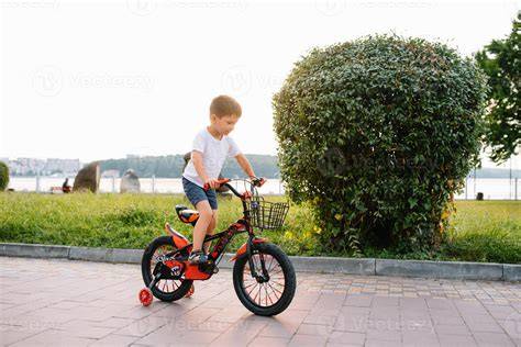 Foto de un niño pequeño feliz montando en bicicleta con pedales