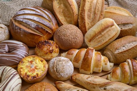 Fotografía artesanal de diversos tipos de pan y empanadas tradicionales sobre un mostrador de panadería
