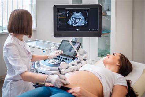 médico realizando una ecografía obstétrica a una mujer embarazada para determinar el bienestar fetal