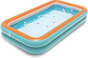 Imagen de una piscina infantil hinchable instalada en un jardín con niños jugando