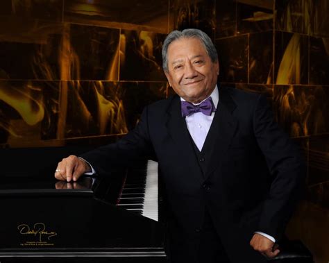 Fotografía histórica de Armando Manzanero en sus inicios profesionales junto a un piano.