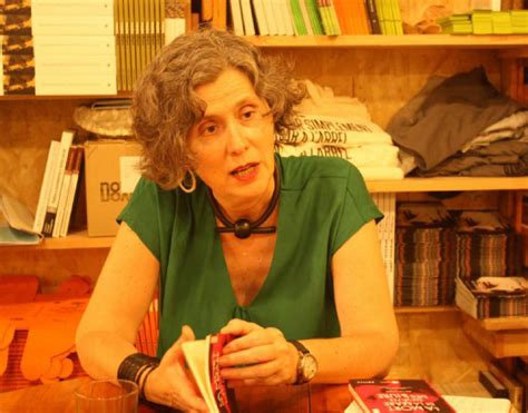 Perfil de Mari Luz Esteban Galarza, enfocada y reflexiva, rodeada de libros y material de investigación.