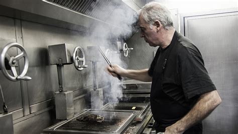 Foto de Bittor Arginzoniz en su restaurante, con la parrilla de fondo