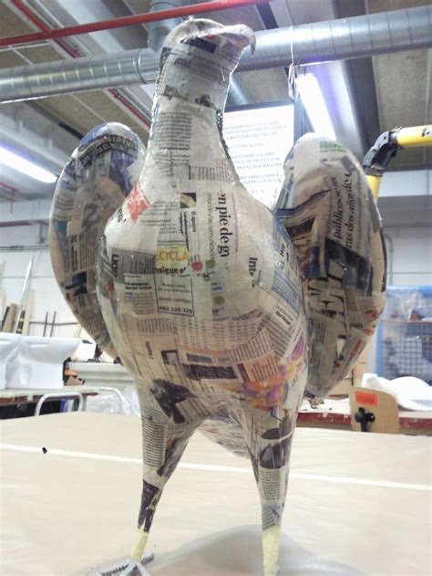 Escultura de barriga de embarazada hecha con papel maché, delicadamente decorada con motivos florales.