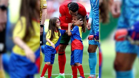 Cristiano Ronaldo abrazando a un niño en un campo de fútbol de Granada, con seguridad de fondo