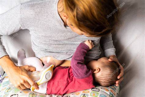 Madre amamantando a su bebé mientras usa discos de lactancia
