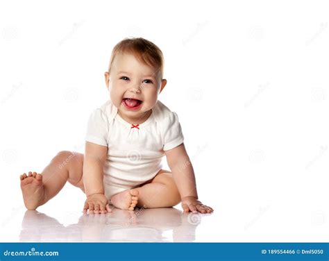 Bebé de 7 meses sentado, mirando un libro y balbuceando