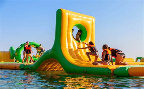 Niños divirtiéndose en un parque acuático hinchable en el mar