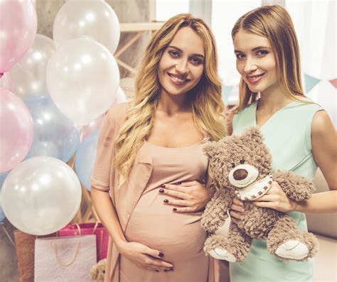Foto de una pareja embarazada celebrando un baby shower con amigos y regalos