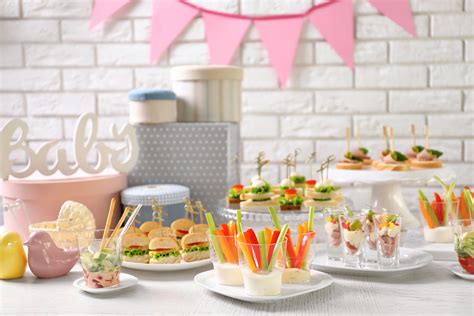 Mesa con un buffet de comida y bebidas sin alcohol para un baby shower