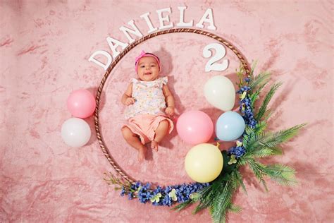 Fotografía profesional de un bebé en una sesión de cumplemes con elementos decorativos suaves y luminosos