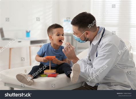 Foto de odontopediatra examinando a un niño en la consulta