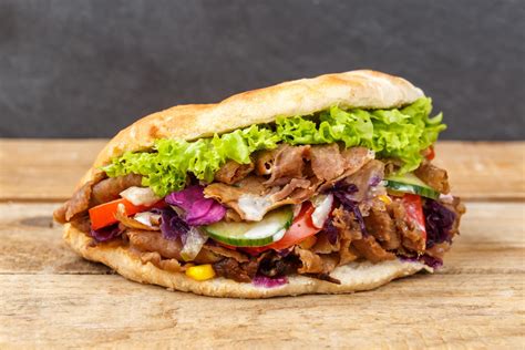 Imagen de un kebab muy grande y abundante, con mucha carne y complementos