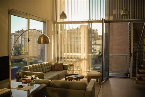 Fotografía de un salón luminoso con grandes ventanales y acceso a terraza