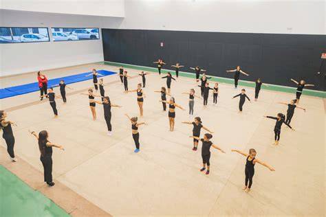 Instalaciones deportivas y gimnastas en entrenamiento técnico de alta precisión