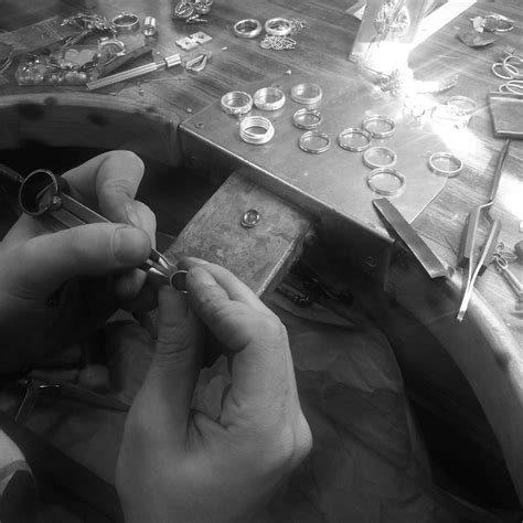 Taller artesanal de joyería, con un orfebre trabajando en un colgante de leche materna
