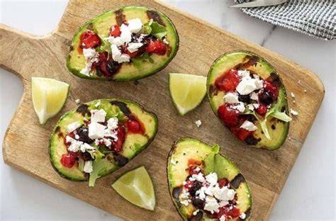 Foto de aguacates frescos y queso feta desmenuzado en un tazón