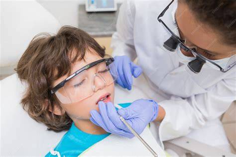 Dentista pediátrico examinando los dientes de un niño en un entorno amigable