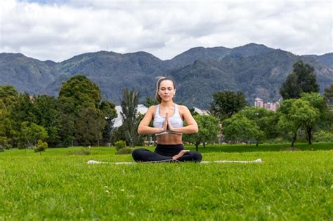 Mujer practicando yoga al aire libre, simbolizando el control del estrés