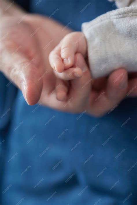 Fotografía de padres sosteniendo tiernamente a su bebé recién nacido.