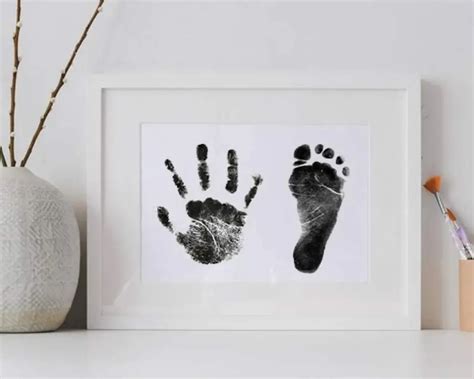 Primer plano de las huellas de la mano y el pie de un bebé en tinta.