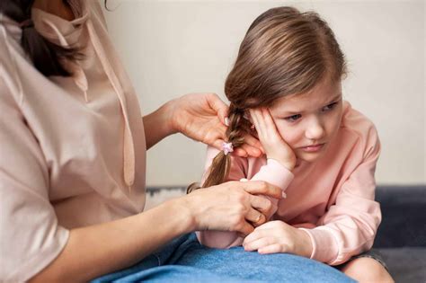 Matrona con bebé, realizando una perforación de oreja de forma delicada