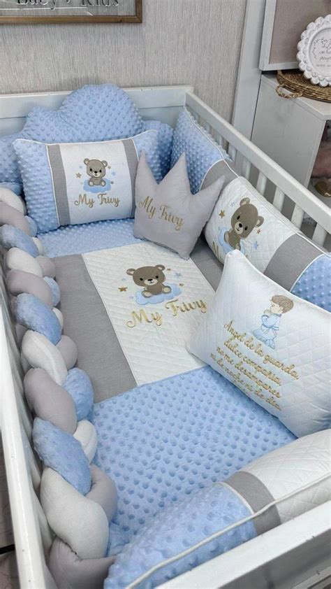 Cuna de bebé decorada con peluches, letras de nombre y dosel