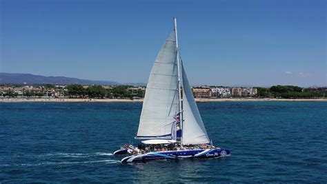 Imatge del catamarà Ocean Fly amb assistents gaudint d'un tast de vins i ostres.