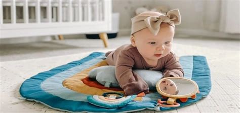 Bebé realizando tummy time en una manta con juguetes