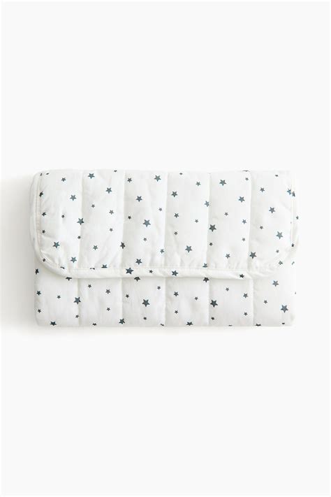 Cambiador plegable sobre cuna con estampado de estrellas grises
