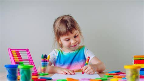 niños pequeños dibujando y coloreando en un aula de jardín infantil