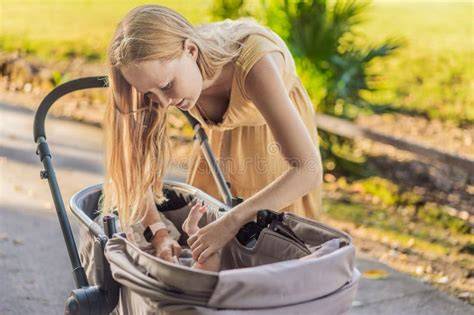 Madre cambiando el pañal de su bebé en un coche, utilizando un cambiador portátil
